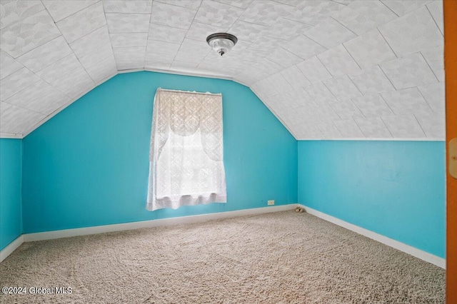 additional living space featuring carpet and vaulted ceiling