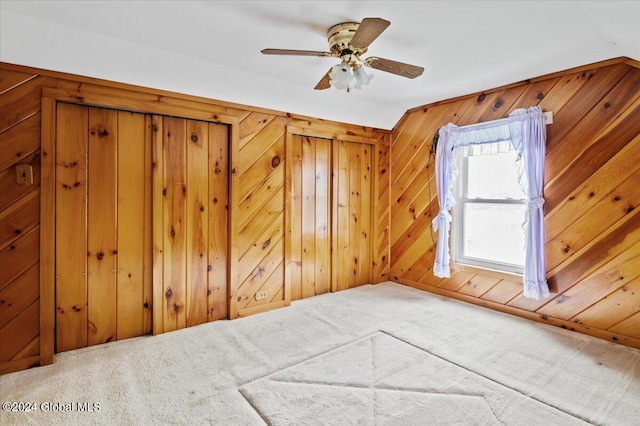 bonus room with carpet, ceiling fan, and wooden walls