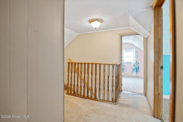 corridor featuring carpet flooring and vaulted ceiling