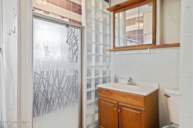 bathroom featuring vanity, toilet, and tile walls