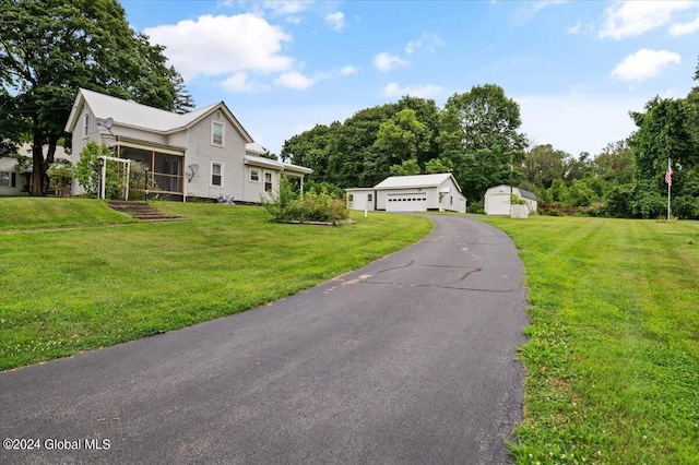 view of front of house featuring a shed, a garage, and a front lawn