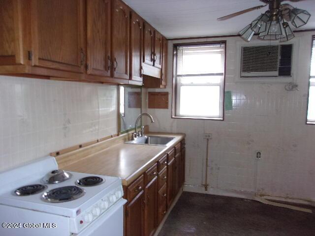 2119 Broadway, Schenectady, NY 12306 - kitchen featuring light countertops, a sink, white electric range, ceiling fan, and tile walls