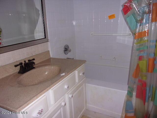 2119 Broadway, Schenectady, NY 12306 - full bath featuring decorative backsplash, shower / tub combo with curtain, and vanity