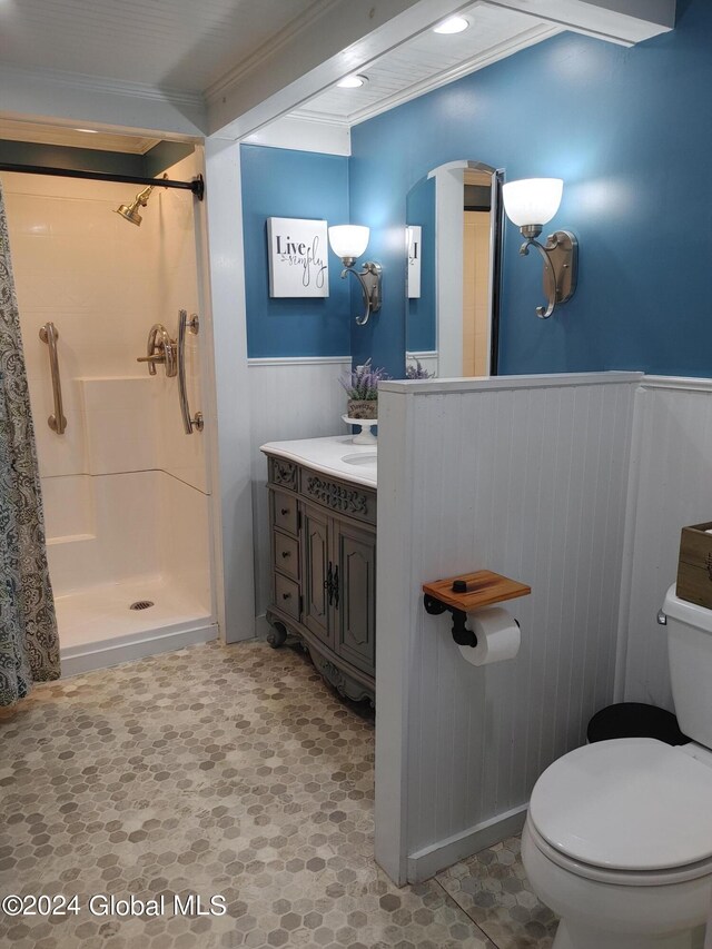 bathroom with walk in shower, toilet, vanity, tile patterned floors, and ornamental molding