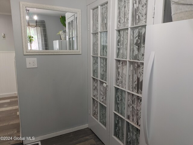 interior details with white fridge and hardwood / wood-style flooring