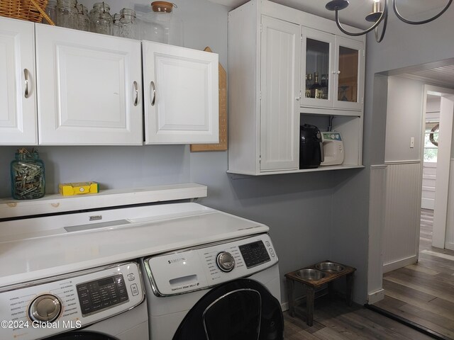 laundry area featuring separate washer and dryer, cabinets, a chandelier, and dark wood-type flooring