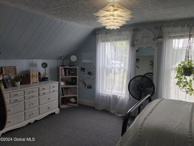 carpeted bedroom with a textured ceiling and lofted ceiling