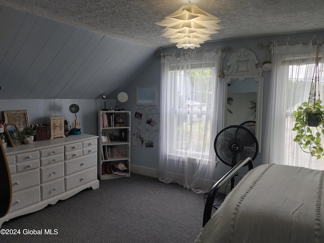 bedroom featuring multiple windows, lofted ceiling, carpet flooring, and a textured ceiling