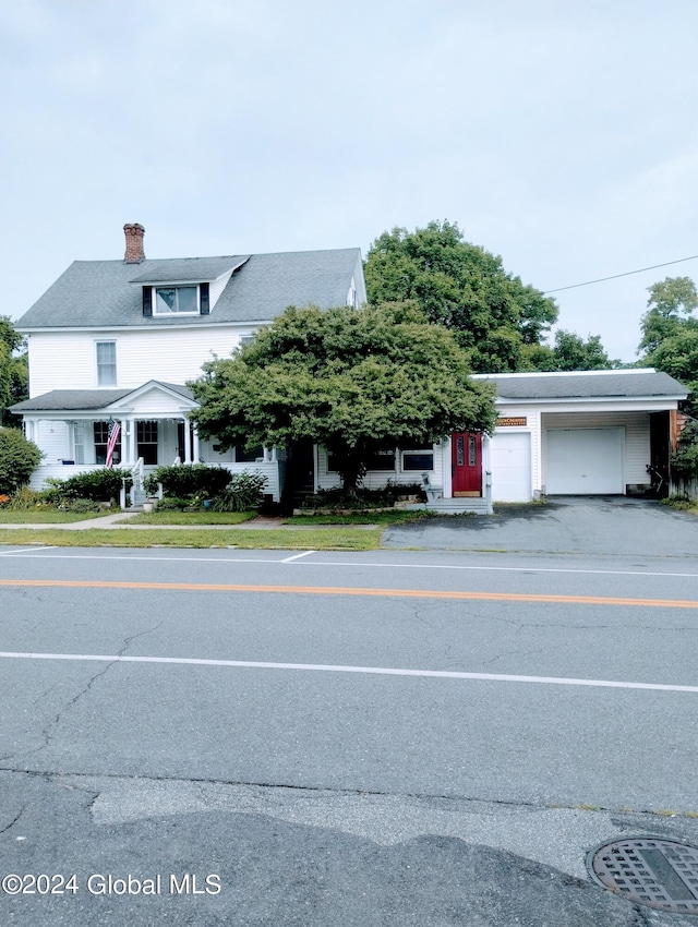 view of front facade with driveway and a chimney