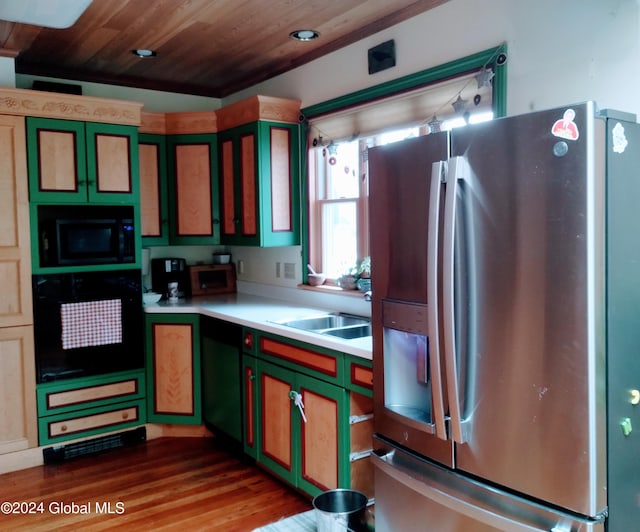 kitchen with black oven, stainless steel fridge, wooden ceiling, green cabinetry, and built in microwave