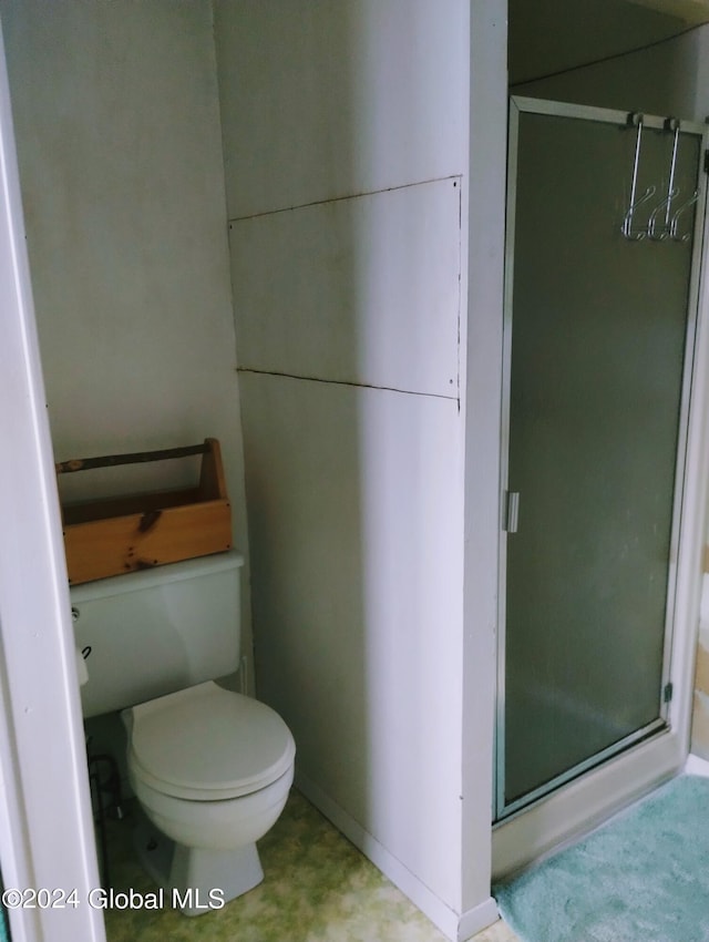 full bath featuring toilet and a stall shower