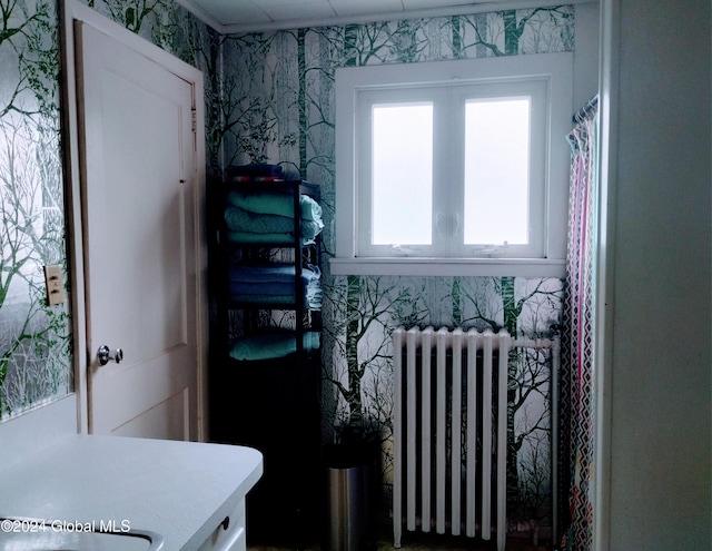 interior space featuring radiator, wallpapered walls, and light countertops