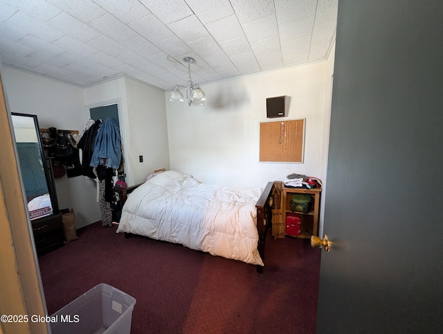 carpeted bedroom with a notable chandelier