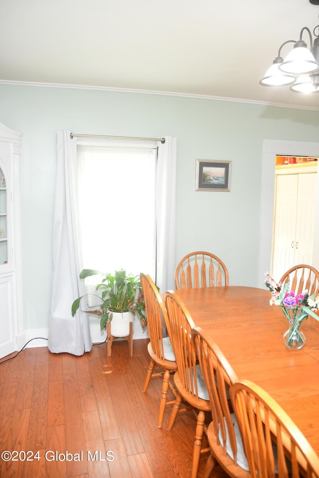 dining area featuring ornamental molding and hardwood / wood-style flooring