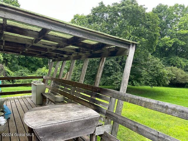 wooden terrace featuring a lawn