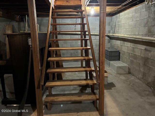 staircase featuring concrete flooring