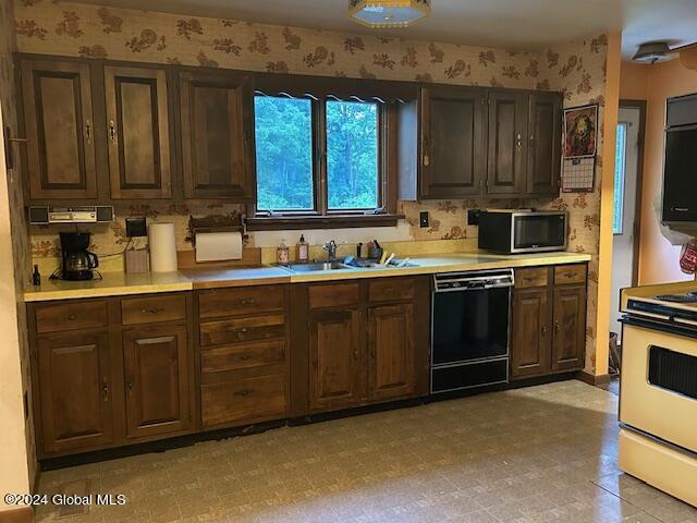 kitchen with a sink, range, dishwasher, stainless steel microwave, and wallpapered walls