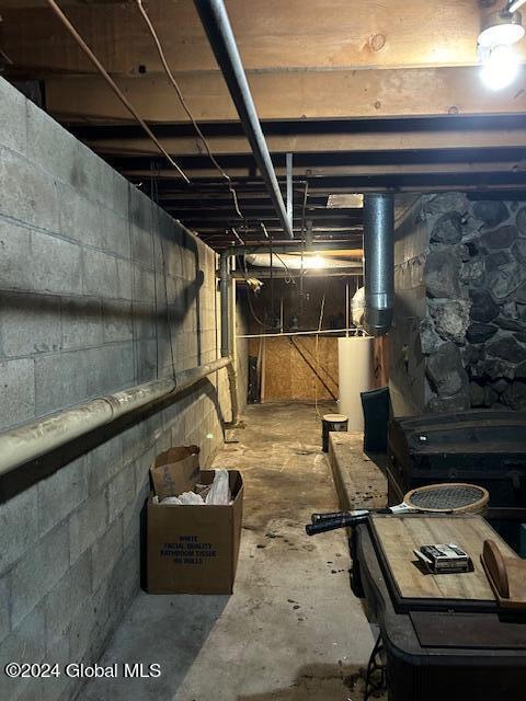 unfinished below grade area featuring water heater