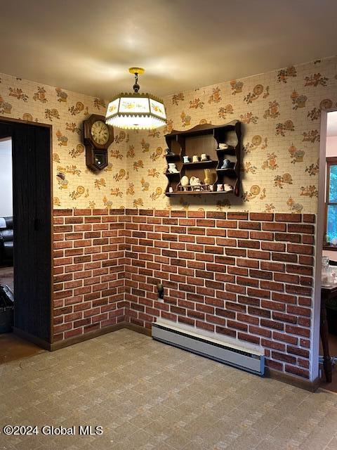 interior space featuring a baseboard heating unit, a wainscoted wall, and wallpapered walls