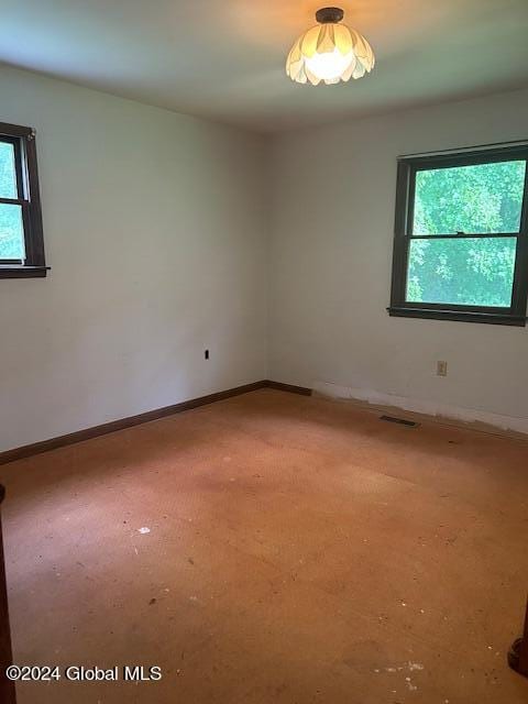 empty room featuring baseboards and visible vents