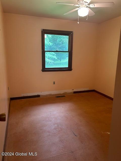 spare room with ceiling fan and baseboards