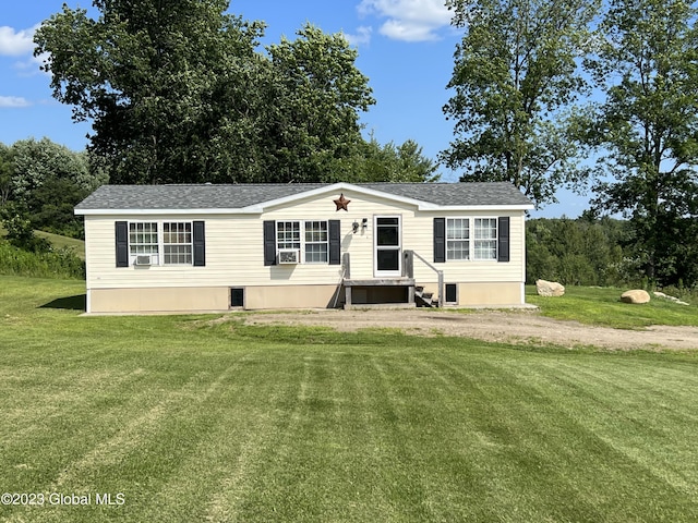 manufactured / mobile home featuring driveway, a shingled roof, a front lawn, and cooling unit