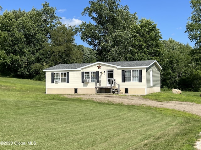 manufactured / mobile home featuring driveway, a front lawn, roof with shingles, and cooling unit