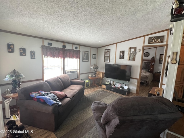 living area featuring a textured ceiling, ornamental molding, and wood finished floors