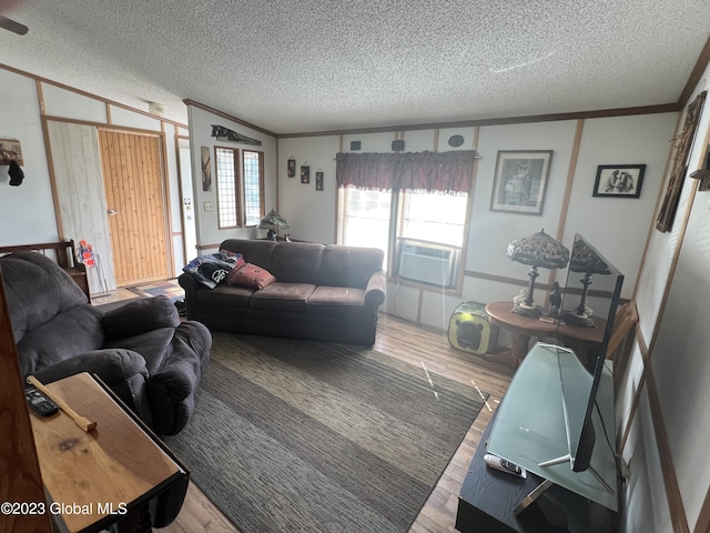 living room featuring a textured ceiling, cooling unit, wood finished floors, and crown molding