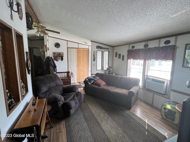 living room featuring lofted ceiling, a textured ceiling, cooling unit, wood finished floors, and ornamental molding