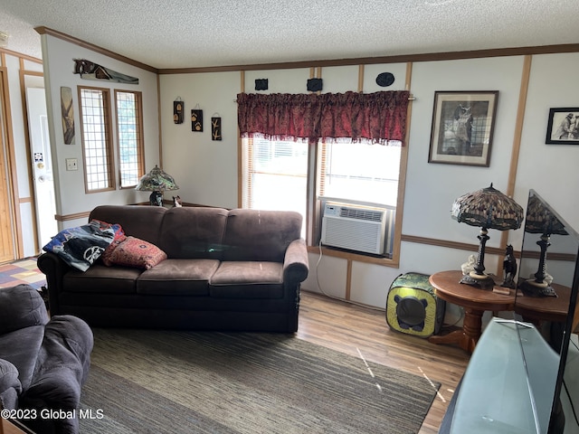 living area with a textured ceiling, light wood-style floors, cooling unit, and crown molding