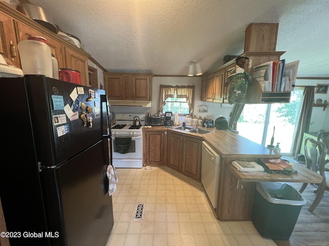 kitchen featuring light floors, white appliances, a sink, and brown cabinets