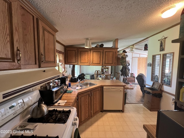 kitchen featuring a ceiling fan, white appliances, brown cabinetry, and a sink