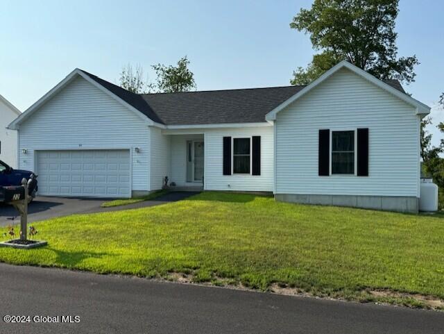 ranch-style home with a garage and a front lawn