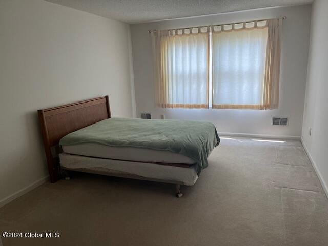 carpeted bedroom with a textured ceiling