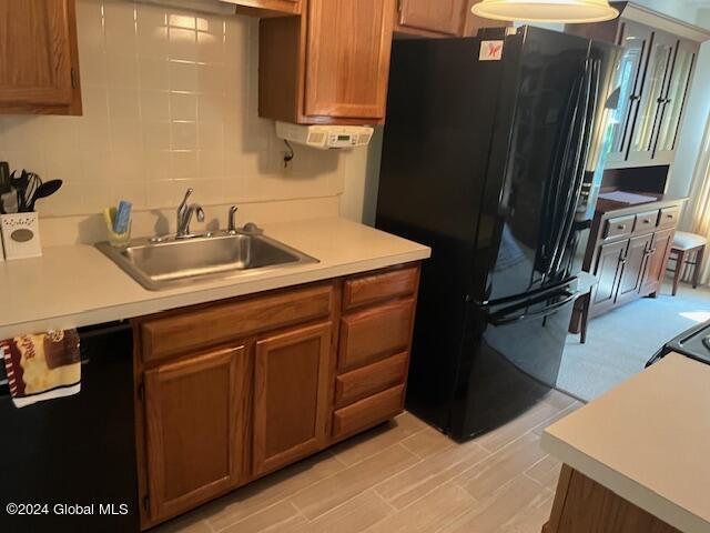 kitchen with backsplash, sink, and black appliances