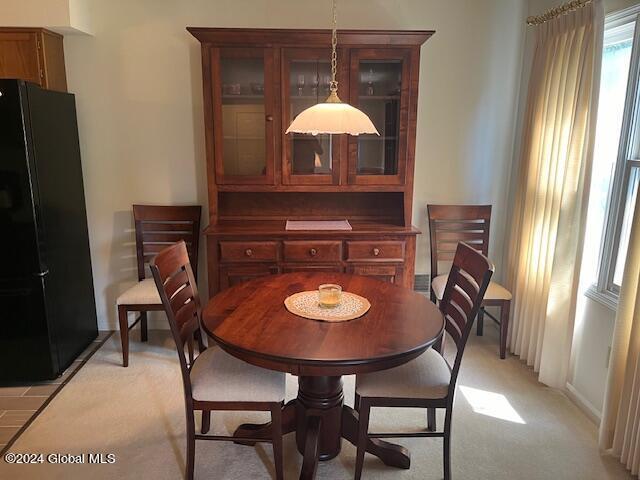 dining space featuring light colored carpet