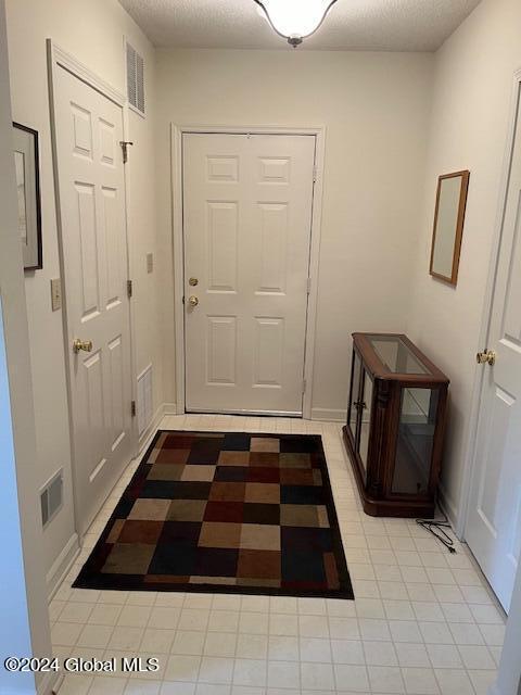 doorway to outside featuring a textured ceiling