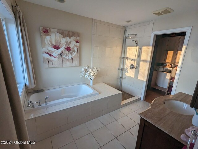 bathroom with vanity, a tile shower, and tile patterned flooring