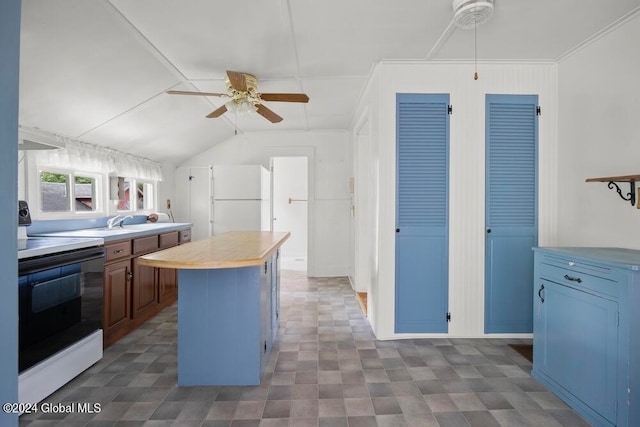 kitchen featuring ceiling fan, a center island, white appliances, and tile patterned flooring