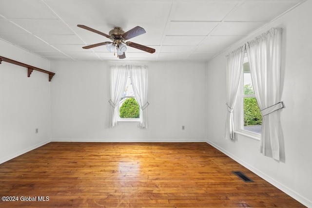 empty room featuring ceiling fan, wood-type flooring, and a healthy amount of sunlight