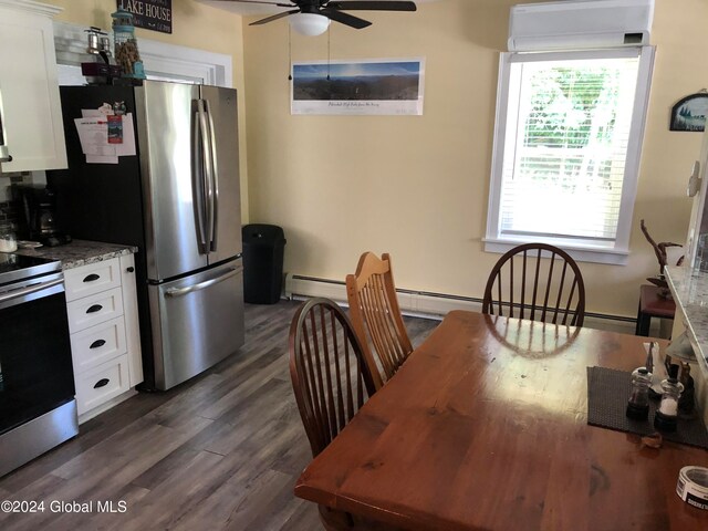 kitchen featuring white cabinets, dark hardwood / wood-style flooring, appliances with stainless steel finishes, light stone counters, and ceiling fan