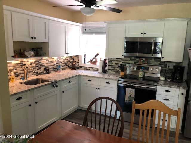 kitchen with backsplash, appliances with stainless steel finishes, sink, and white cabinets