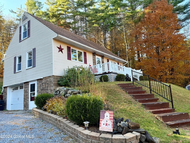 view of side of home with a wooden deck and a garage