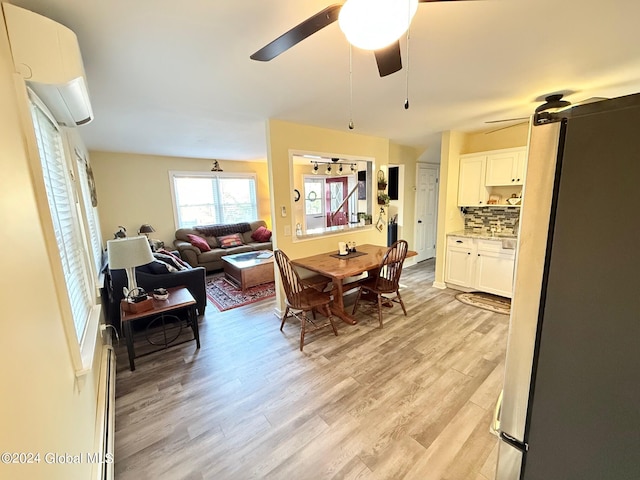 dining space featuring a wall mounted air conditioner, light wood-type flooring, and ceiling fan