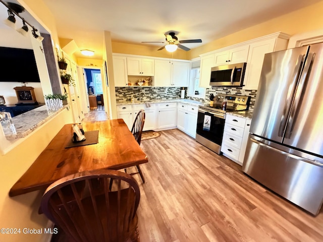 kitchen with decorative backsplash, ceiling fan, white cabinetry, light hardwood / wood-style floors, and stainless steel appliances