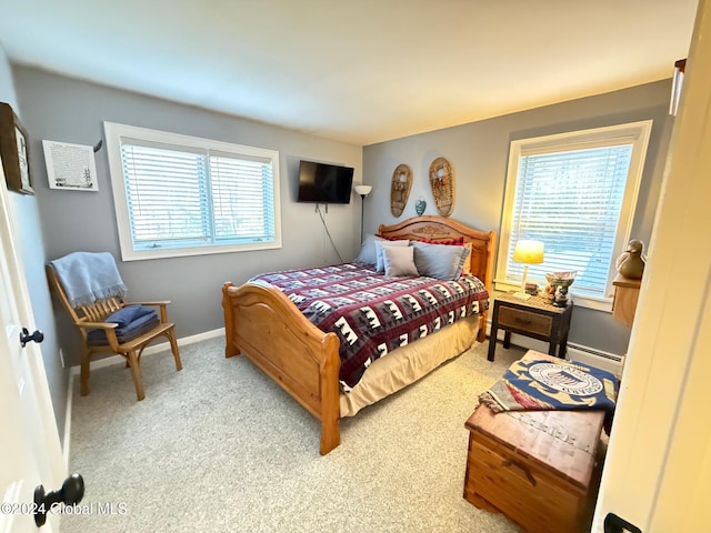 carpeted bedroom featuring a baseboard heating unit and multiple windows