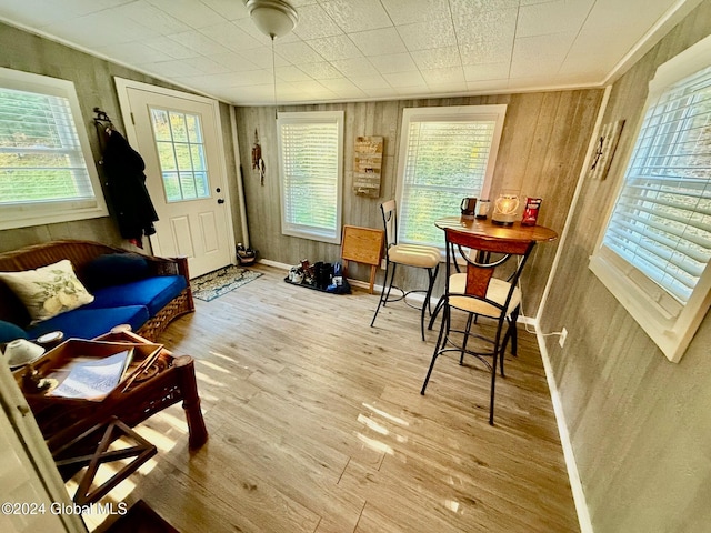 sitting room featuring wood walls, a wealth of natural light, and hardwood / wood-style floors