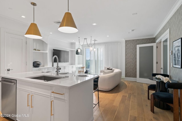 kitchen with a sink, crown molding, light wood-type flooring, white cabinetry, and stainless steel dishwasher