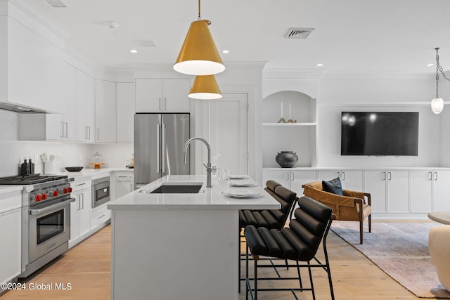 kitchen featuring visible vents, a sink, light countertops, appliances with stainless steel finishes, and open floor plan